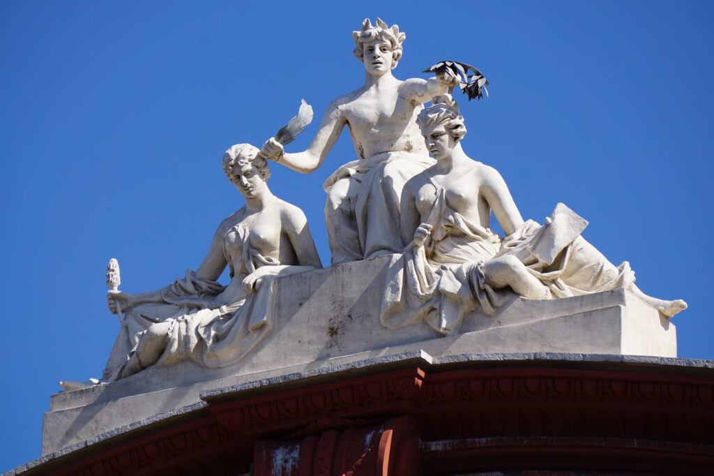 Close-up of artistic sculptures on a historic building in Bari, Italy, under a clear blue sky.