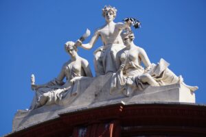 Close-up of artistic sculptures on a historic building in Bari, Italy, under a clear blue sky.