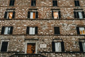 Low-angle view of an old brick façade in Perugia, Italy, showcasing traditional architecture.